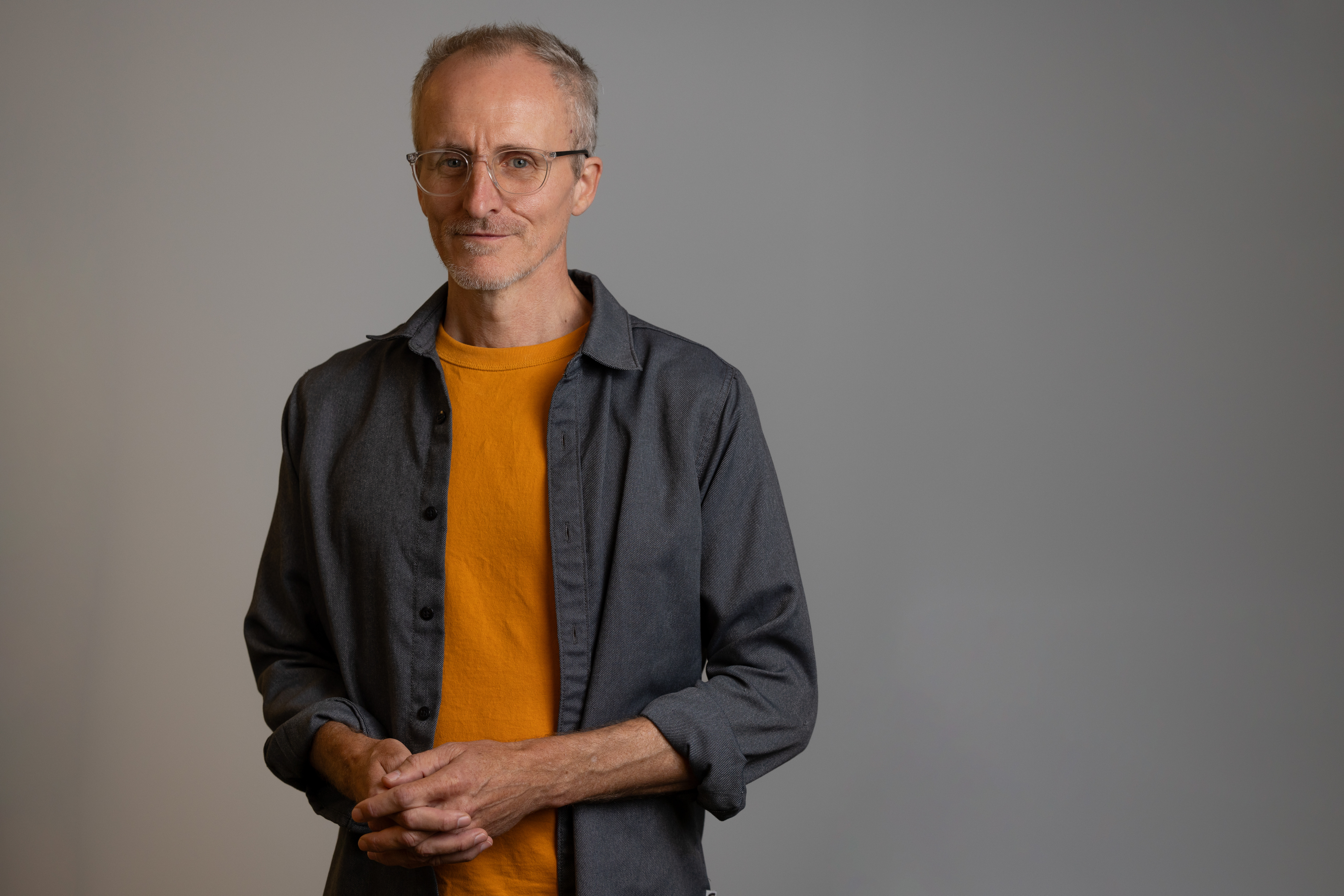 A man with glasses, smiling
