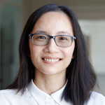 A smiling women with dark hair and glasses